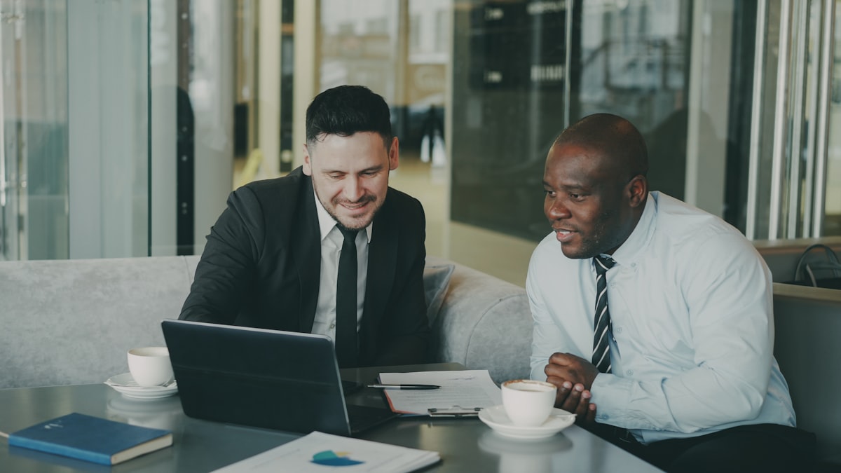 Two professionals collaborating on a laptop, discussing MISP consulting and migration
