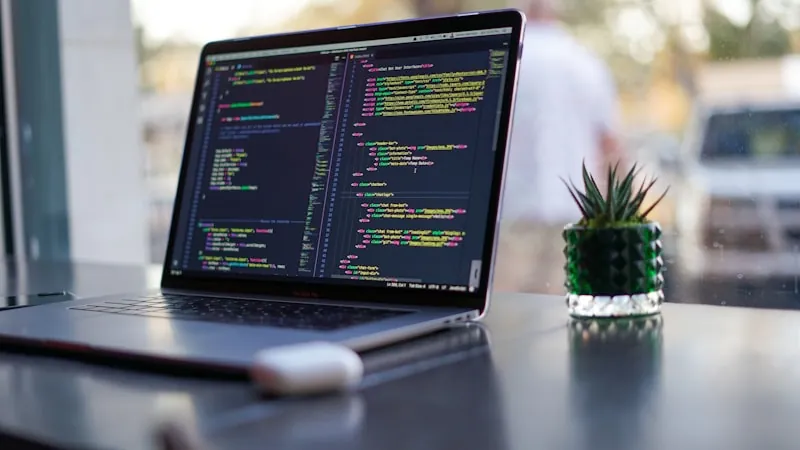 Laptop on a desk displaying code in an editor