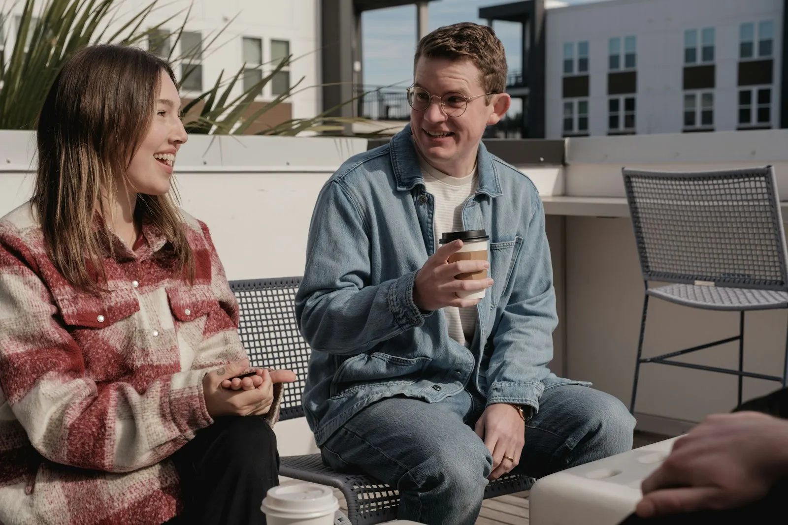 Two people sitting and talking on a rooftop